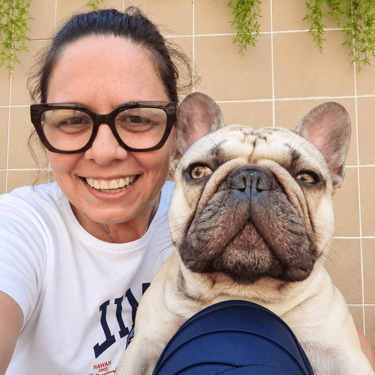 Tia Nena sorrindo ao lado do Fred, um buldogue francês de orelhas em pé